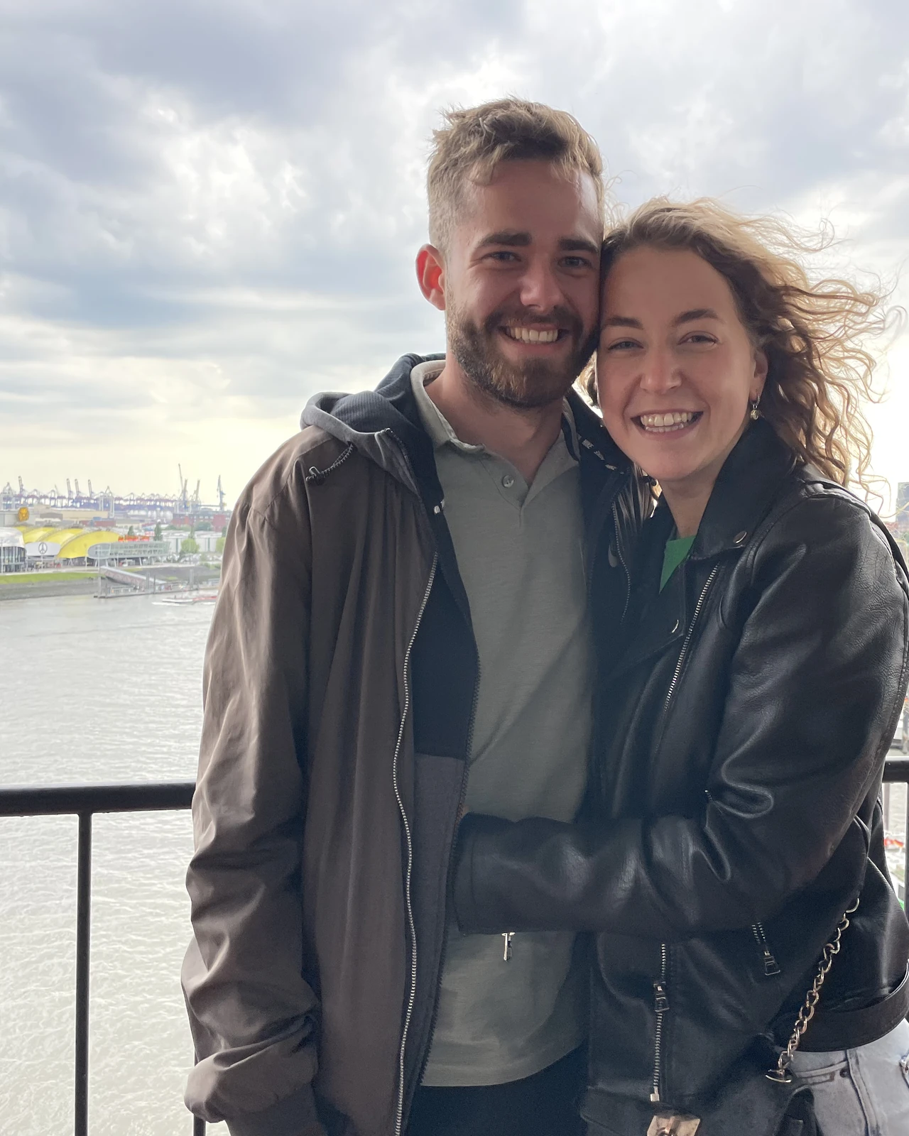 Laurin und Diana lachend auf einer Aussichtsplattform über dem Hamburger Hafen