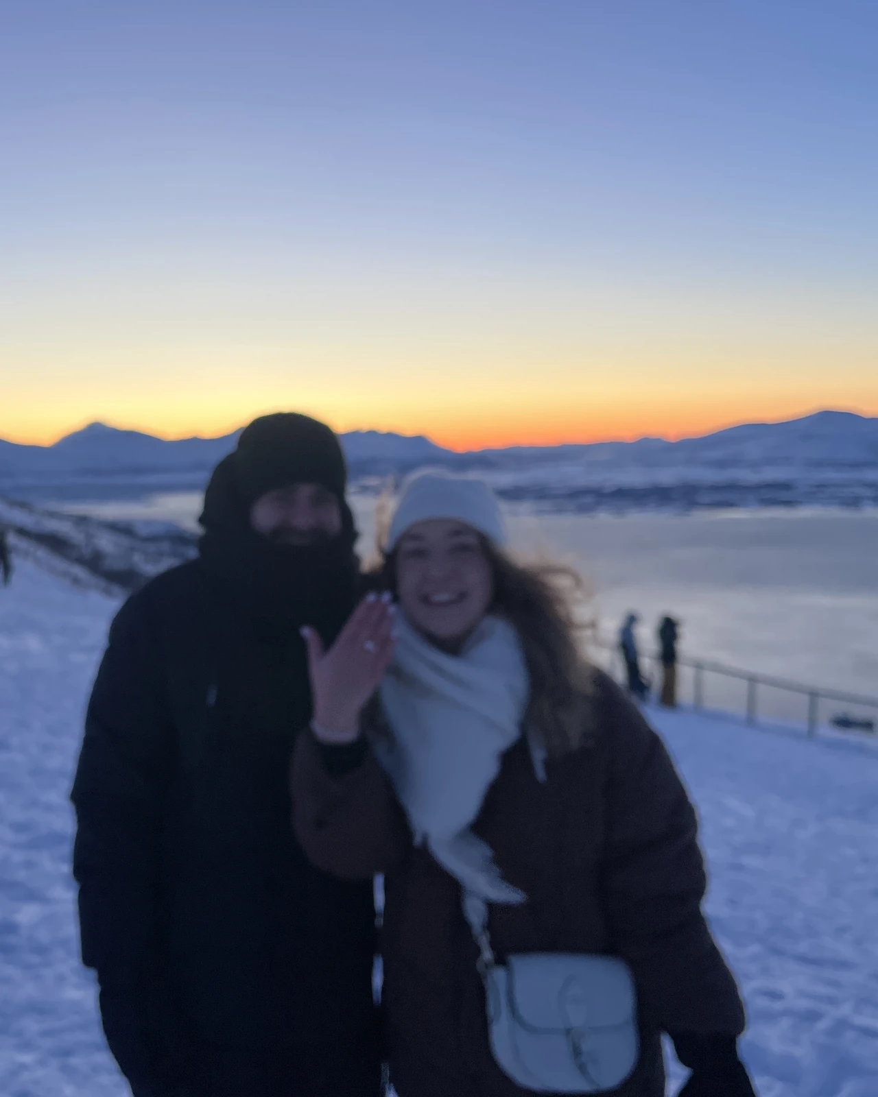 Laurin und Diana im Schnee über dem Fjord bei Tromsø, Diana zeigt ihren Ring